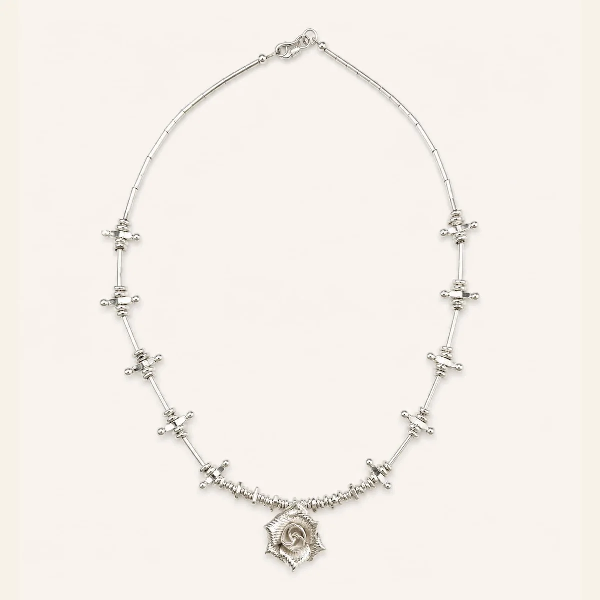 Silver rose necklace on a light background