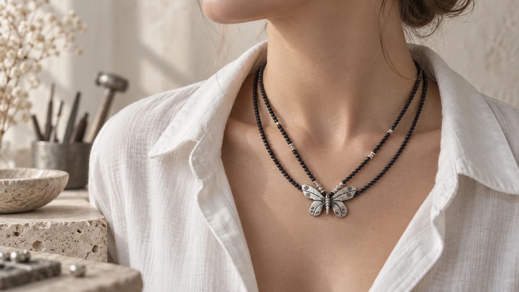 Handcrafted silver and black spinel necklaces worn over white linen
