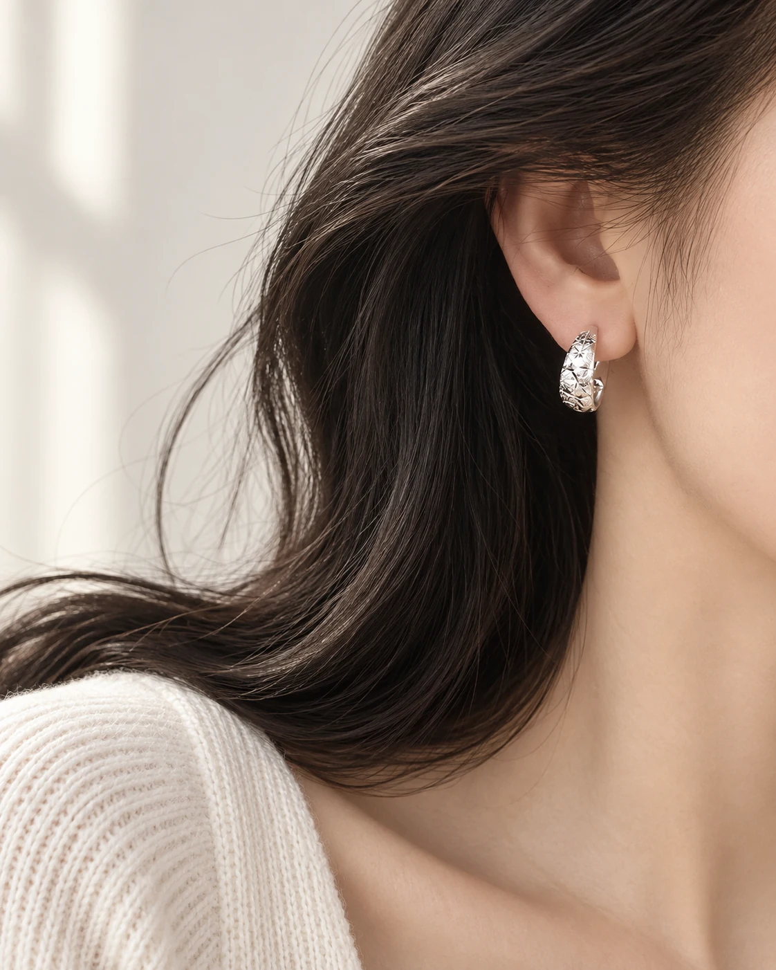 Geometric silver earring worn in profile