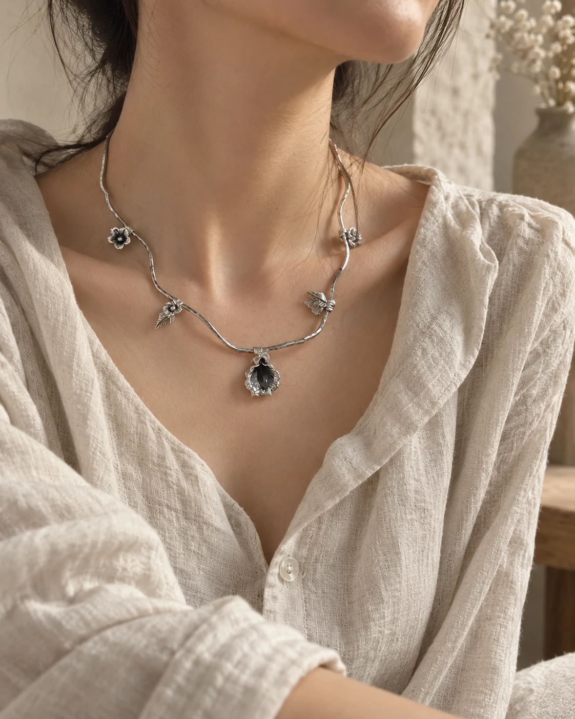 Silver necklace worn at the collarbone